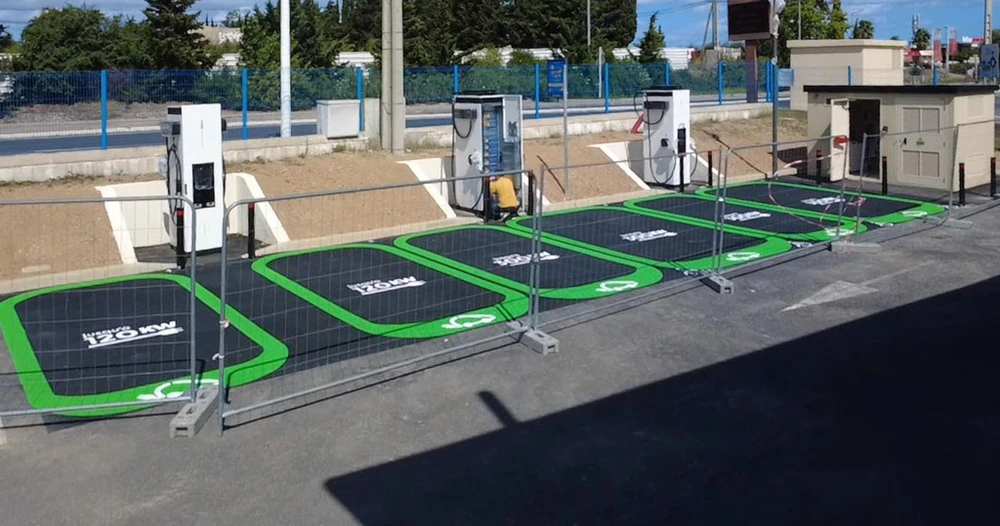 Électricien professionnel en tenue de travail avec gants blancs intervenant sur un tableau électrique industriel